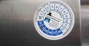 Prüfsiegel auf einer Küchenabluftanlage, das die durchgeführte Reinigung und Wartung dokumentiert – essenziell für Hygiene und rechtliche Sicherheit.